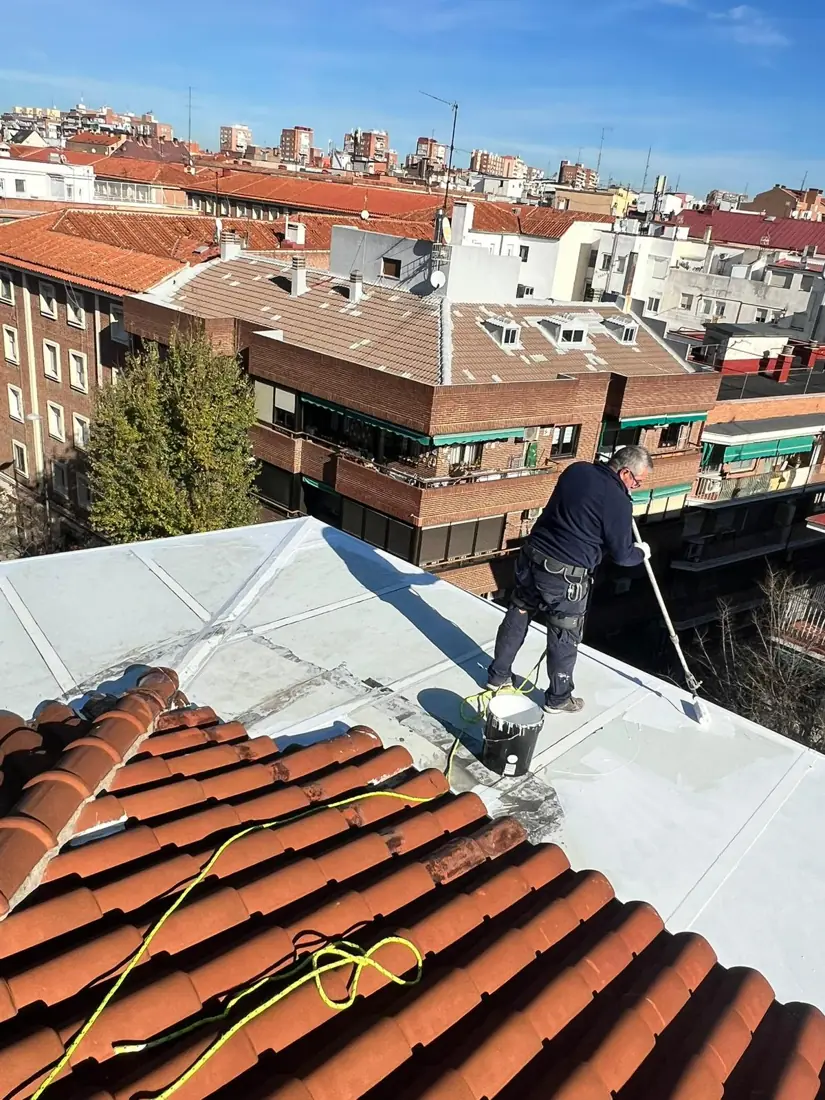 Operario aplicando impermeabilizante en un tejado de Madrid